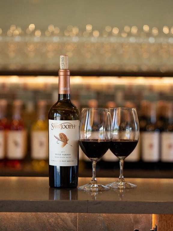 A bottle of Swan Oak wine is on a bar counter with two glasses of wine at Alante Homes at Spring Run, Caldwell