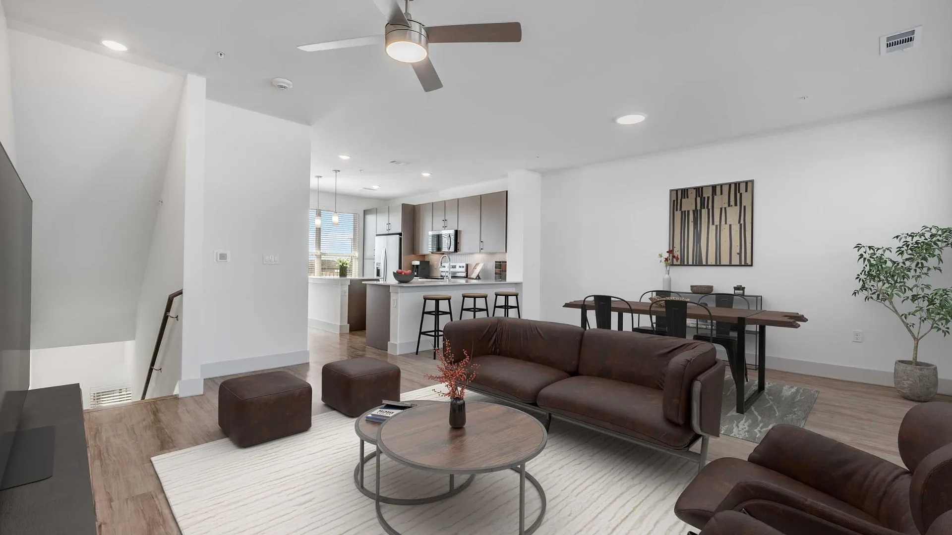 Modern living room with a stylish sofa, coffee table, and an open kitchen area.