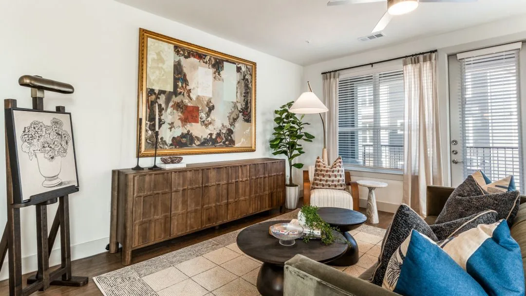 Modern living room with art, plants, and stylish furniture.