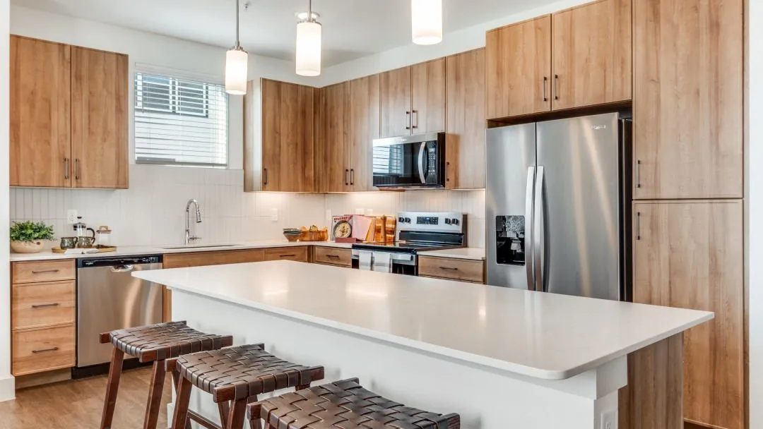 Modern kitchen with wooden cabinetry and stainless steel appliances.