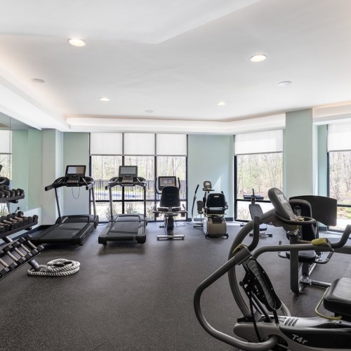 The fitness center at Sylvan Woods Evesham senior living apartments in South Jersey, featuring cardio equipment.