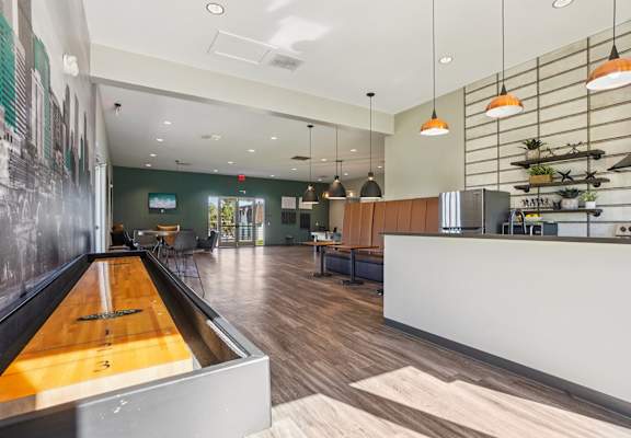 Community clubhouse at Willowstone Apartments in Southeast Denver with seating areas, wood-style flooring, and updated gathering spaces for residents