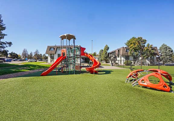 Outdoor playground with slides and climbing structures at Willowstone Apartments in Denver CO 80231, featuring open-air amenities for residents