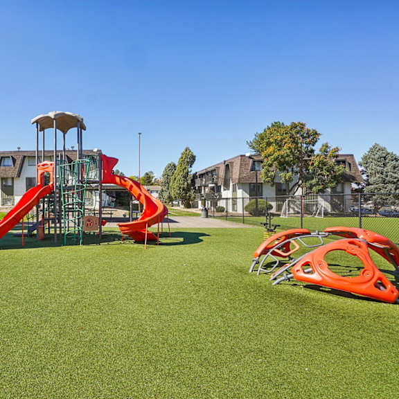 Outdoor playground with slides and climbing structures at Willowstone Apartments in Denver CO 80231, featuring open-air amenities for residents