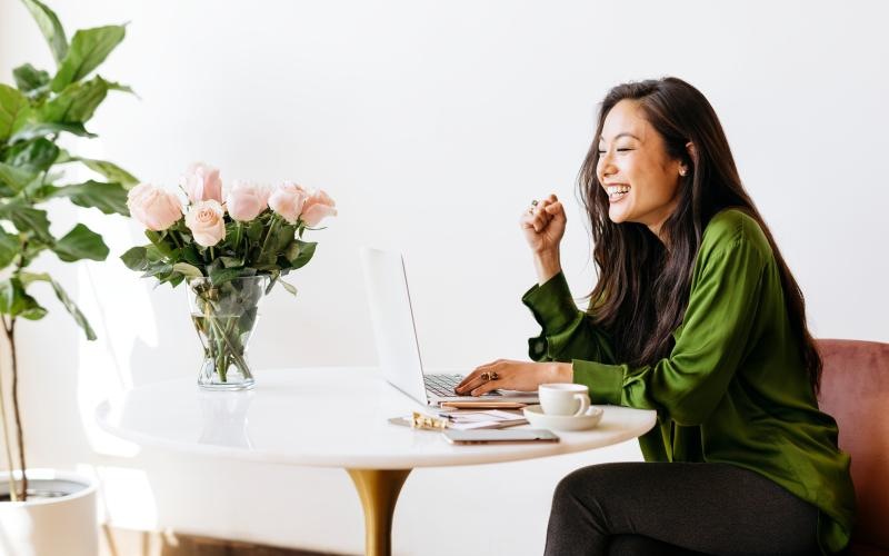 a woman sitting at a table with a computer