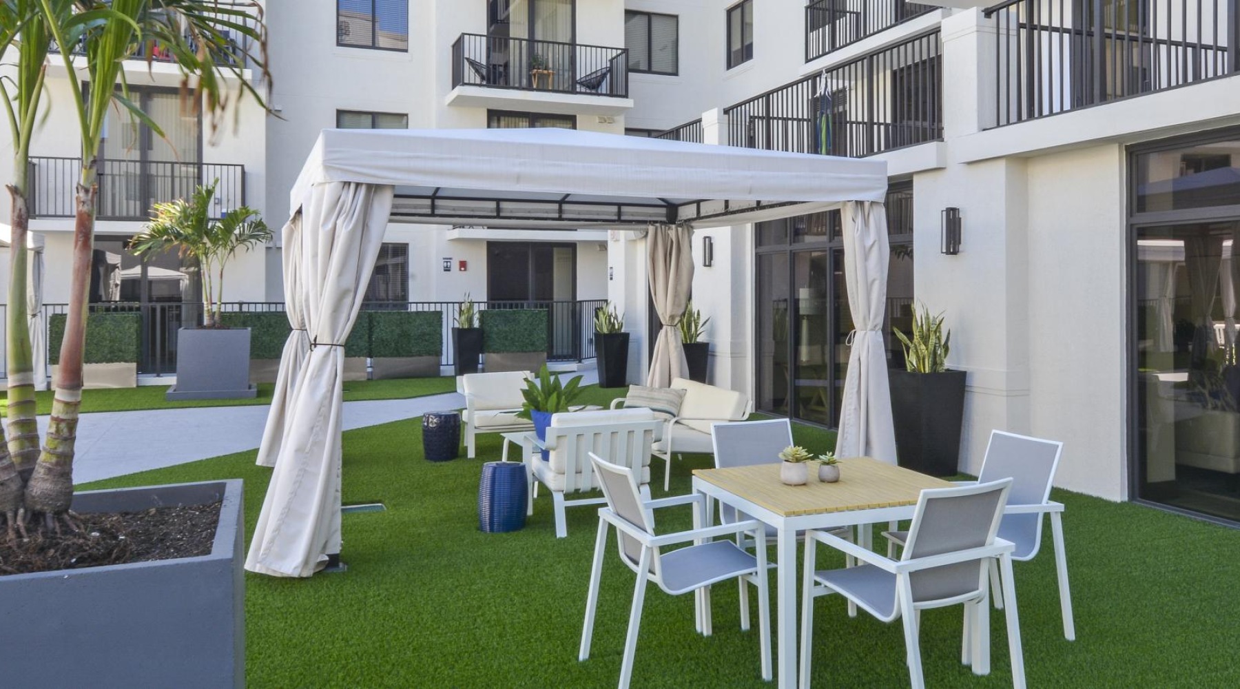 a table and chairs on a lawn outside a building