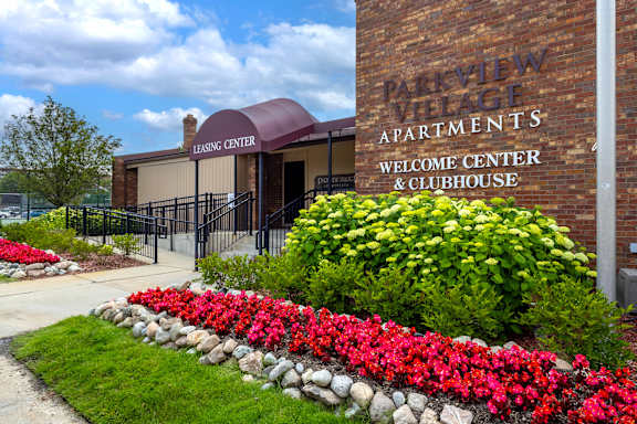 A brick building with a sign that says Parkview Village Apartments.