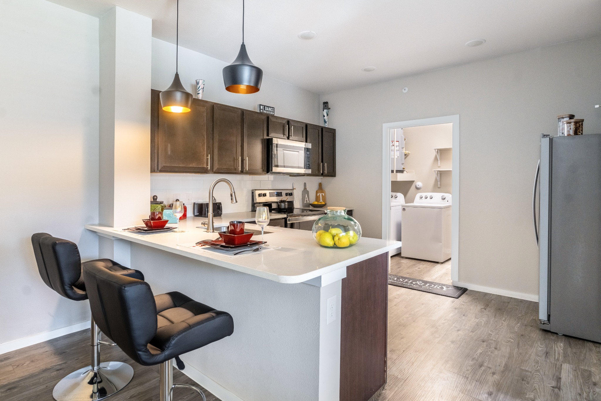 Modern apartment kitchens with in-unit laundry inside homes at Landmark at Crowley