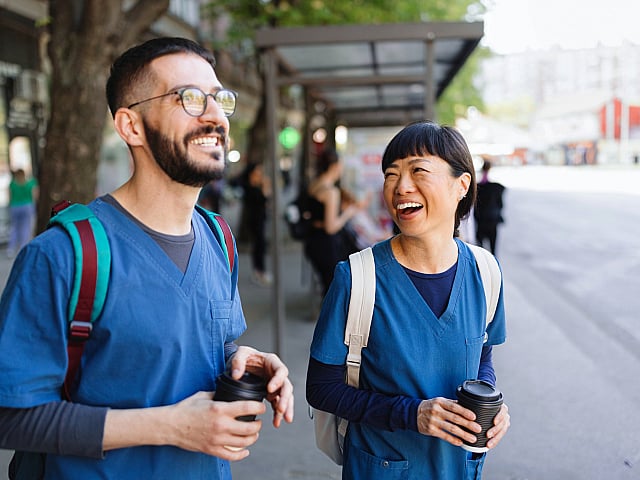 Smiling health care workers commuting.