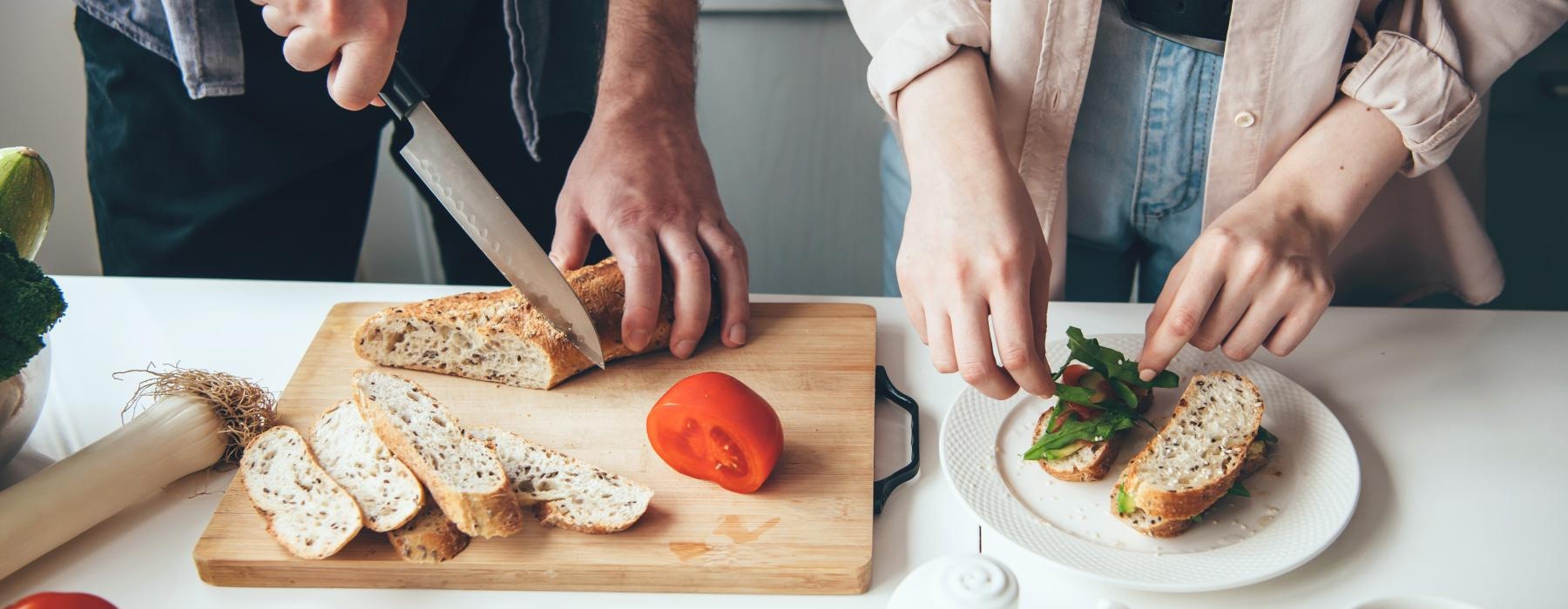 man and woman prepare food on kitchen island