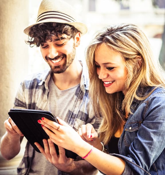 a man and a woman looking at a tablet computer