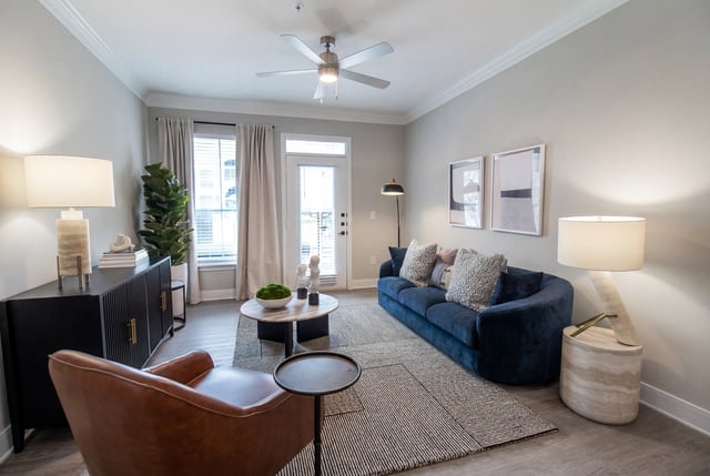 Living room with a blue sofa, brown armchair, coffee table, and side table.