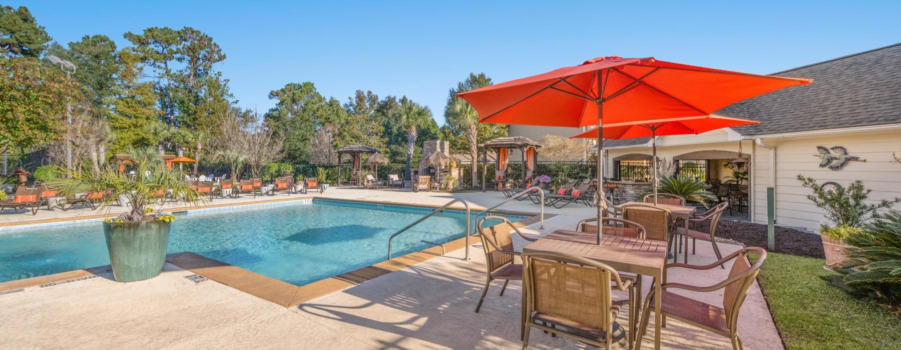 a pool with chairs and umbrellas by it