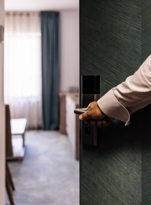 close up view of a hand opening a door leading into an apartment
