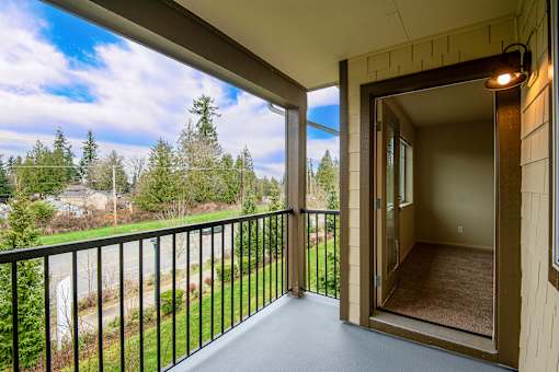 A balcony with a view of a road and trees.