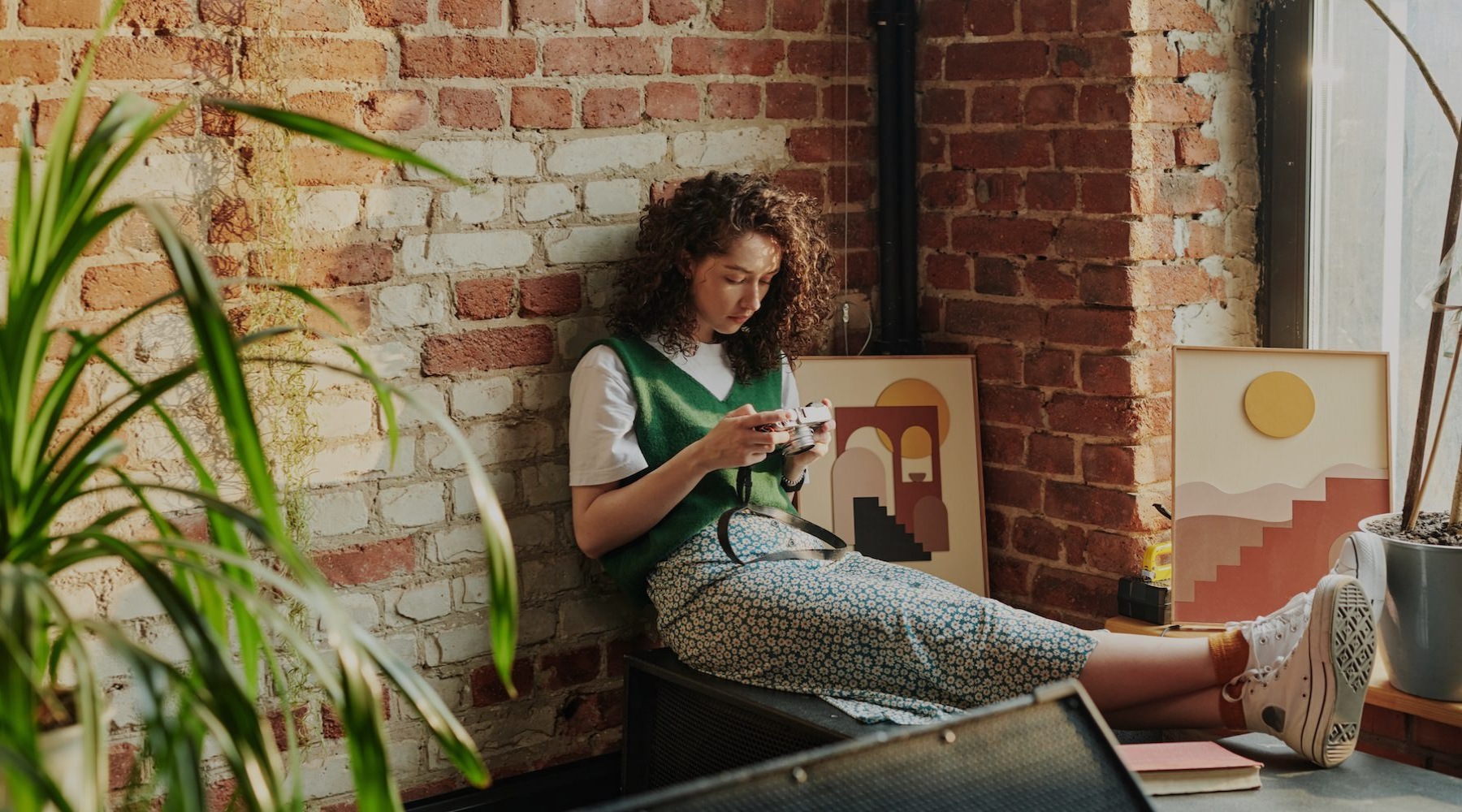 a person sitting in a corner looking at a phone