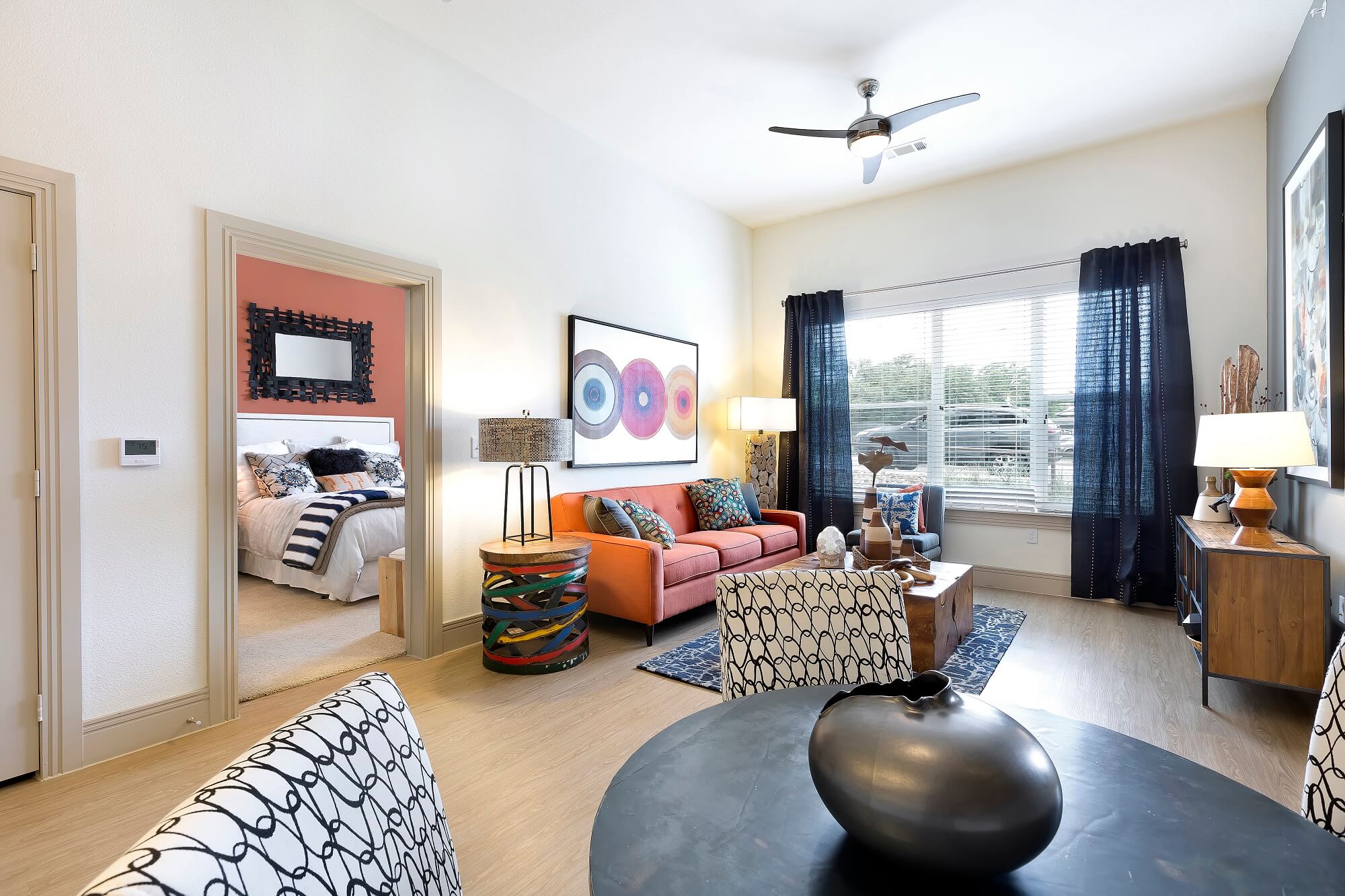 bright living room with blue decor, large window, and view of the bedroom