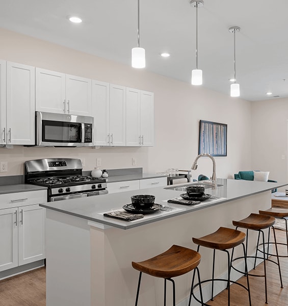 A kitchen with white cabinets and a grey counter top.
