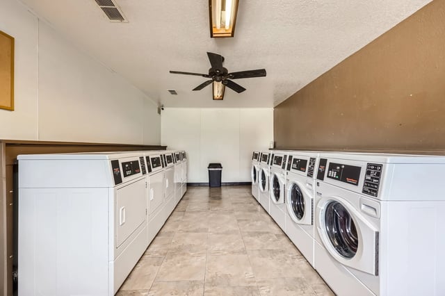 Laundry room with multiple washers and dryers.