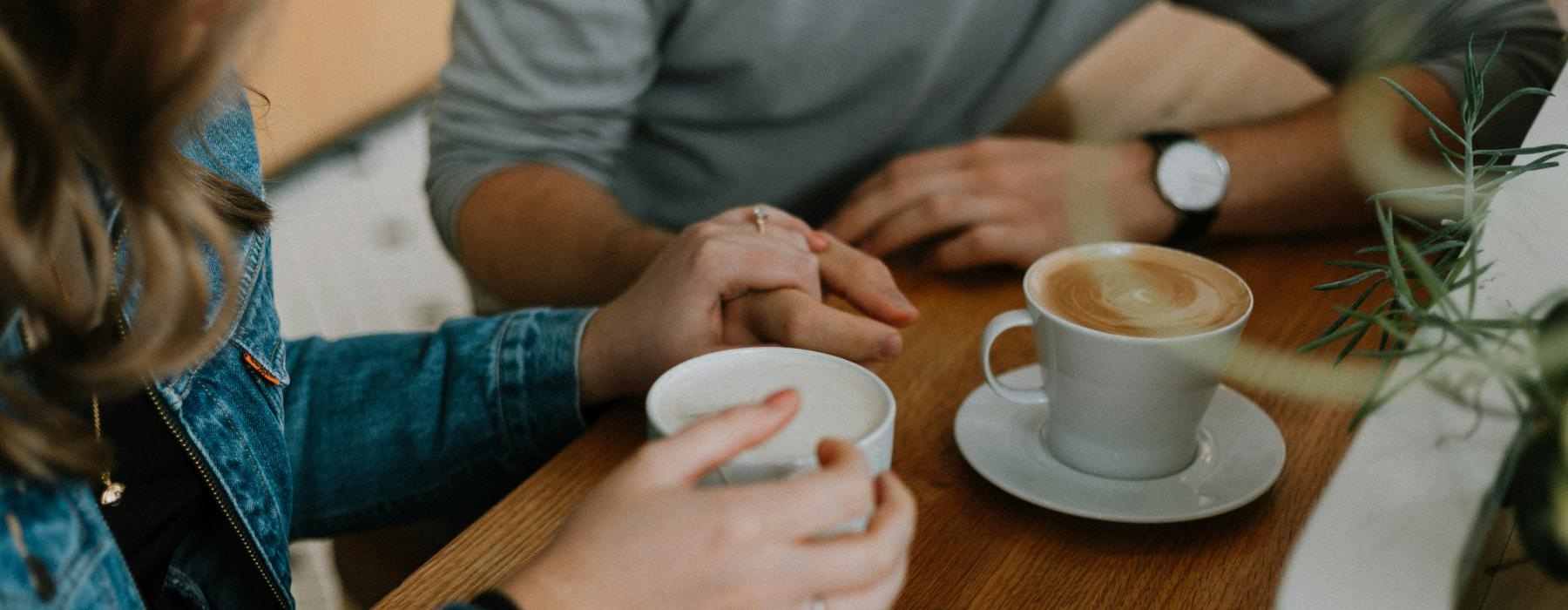 a couple of people sitting at a table with coffee