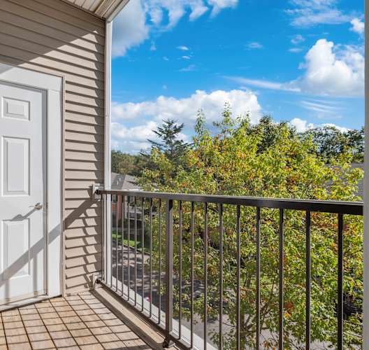 A balcony with a white door and a metal railing.