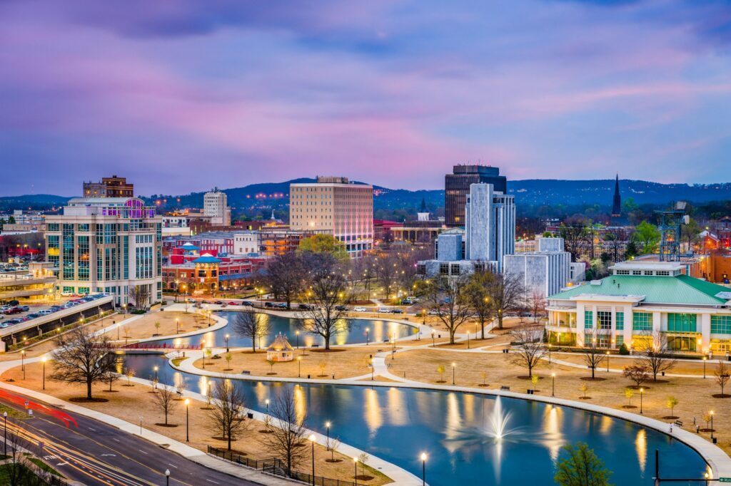 Stunning nighttime skyline of Huntsville, AL, illuminated against the dark sky, highlighting the city's growth and development.