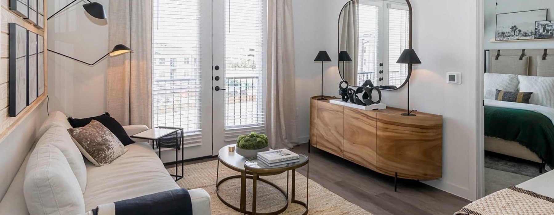 a living room with a couch, coffee table and a mirror