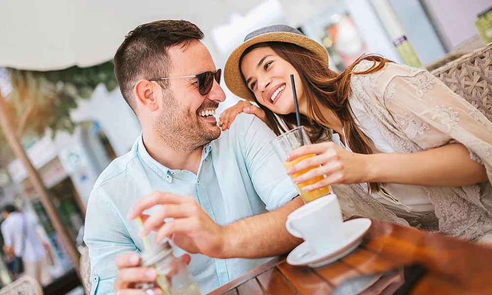 man and woman holding drinks smiling