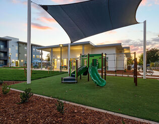 Outdoor playground with shade canopy in grassy area