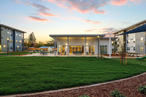 View of back of lobby and communal spot in grassy area with seating