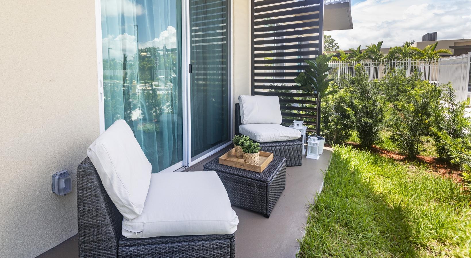 a patio with a couch and a table and chairs