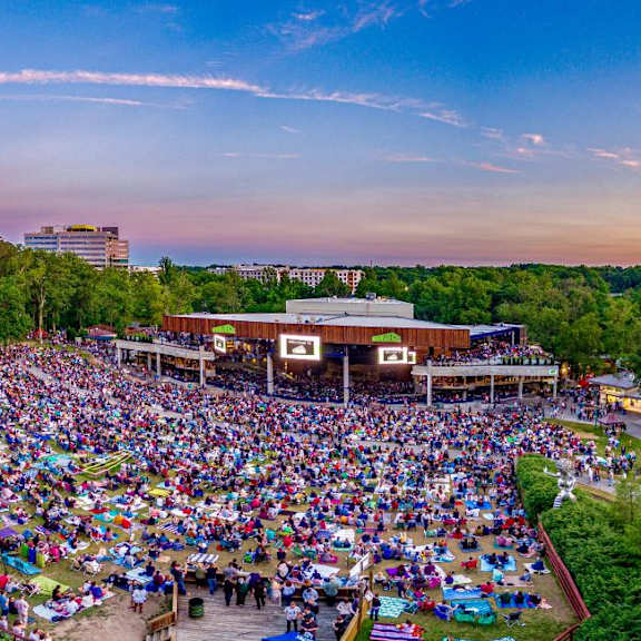 A large crowd of people gathered in an outdoor amphitheater.