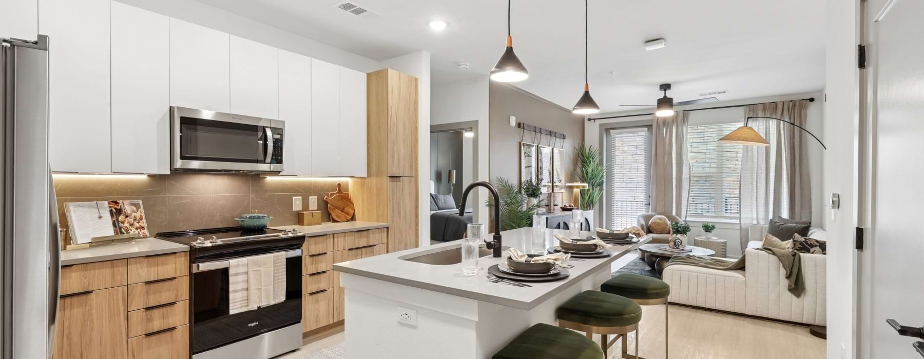 Kitchen with white cabinets and wood accents at Solis Peachtree Corners apartments
