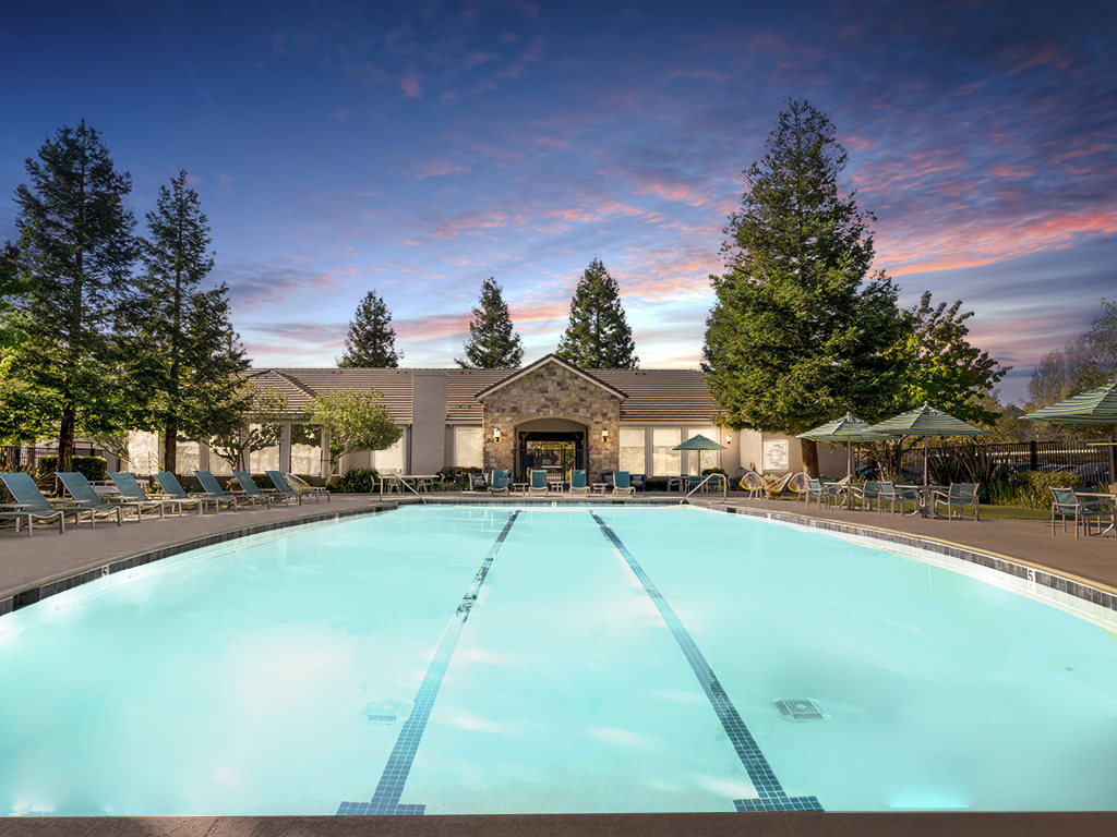 Pool with deck seating and umbrellas