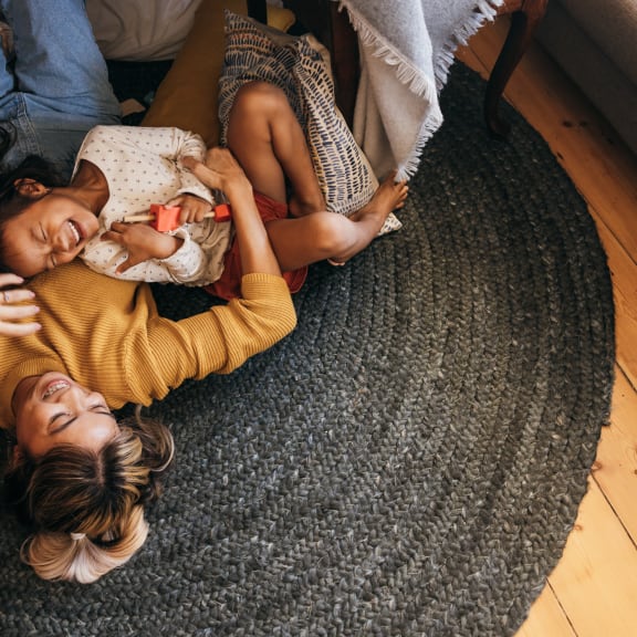 two women laying on the floor with a baby at Fiore Townhomes, Venice, 34275