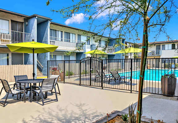 our apartments have a pool and a patio with tables and chairs