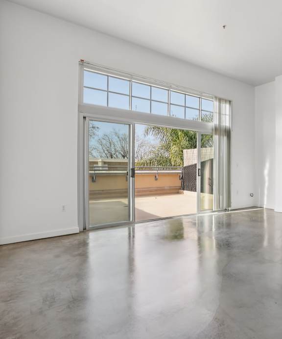A large empty room with a sliding glass door.