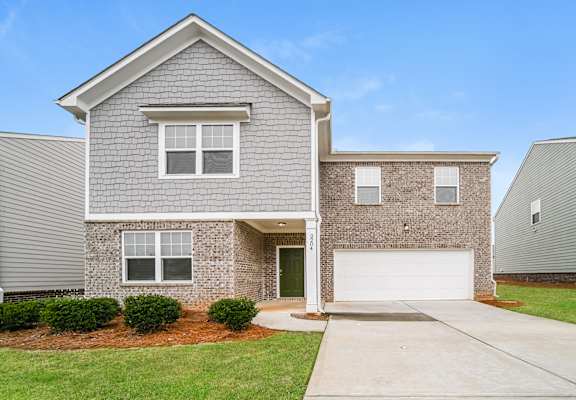 A house with a grey roof and a garage door.
