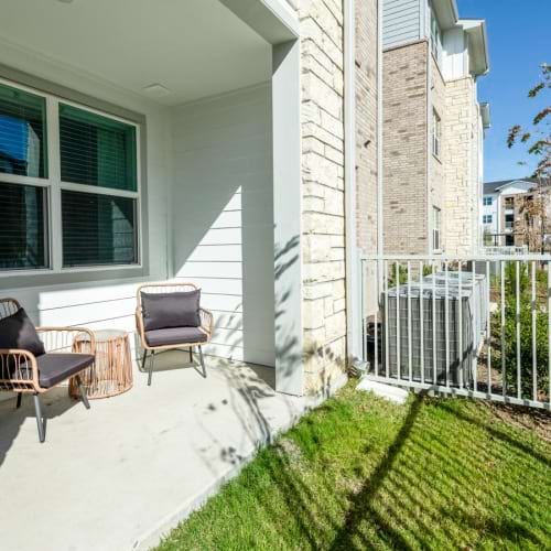 A patio with chairs and a fence at Ascend at 720 pet friendly apartments in Cross Roads, Texas.