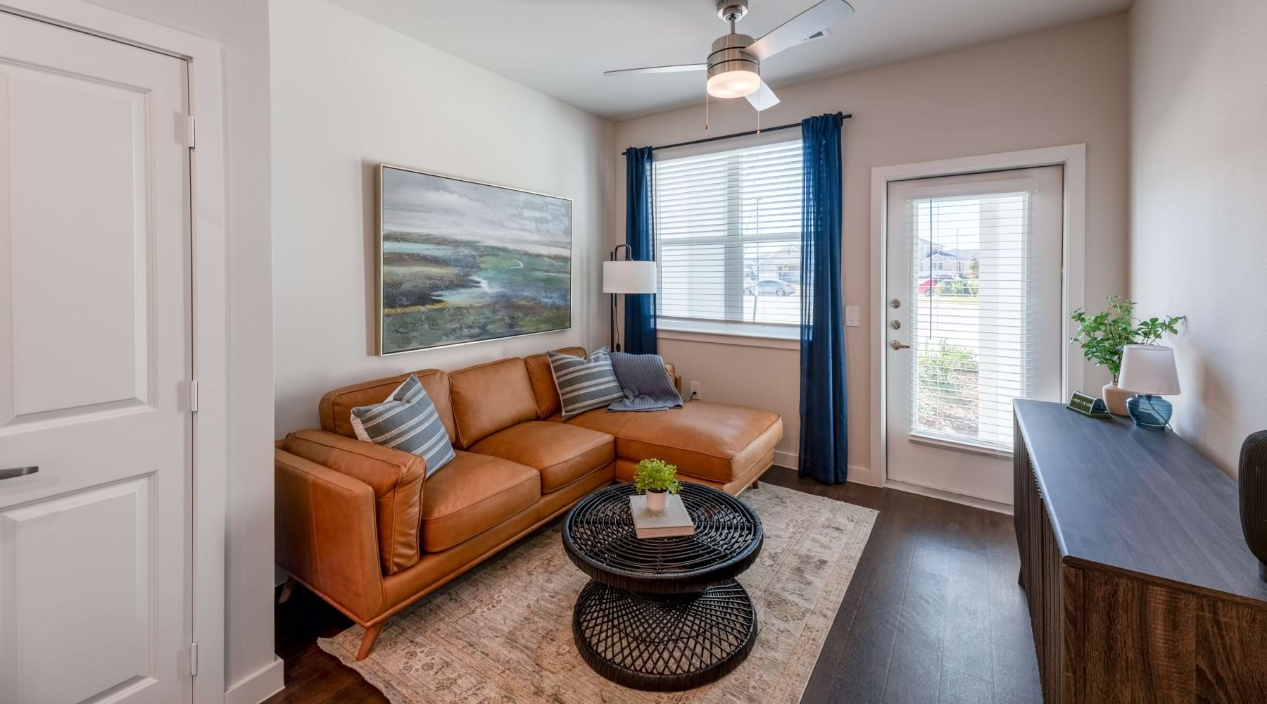 Living room area with a couch and a patio door at Ascend at 720 apartments for rent in Cross Roads, TX.