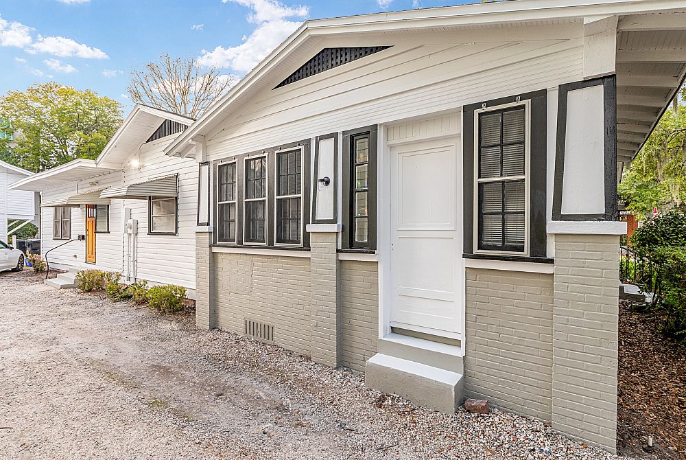 Charming single-story home with a modern exterior, featuring classic black and white details and a welcoming entrance.
