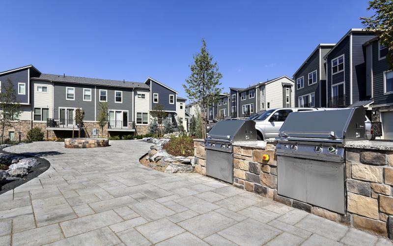 a stone paved area with a grilling station