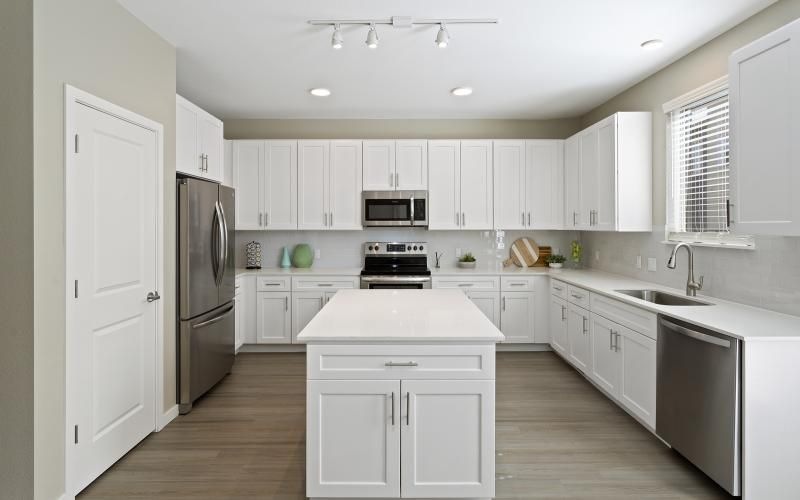 a kitchen with white cabinets and an island