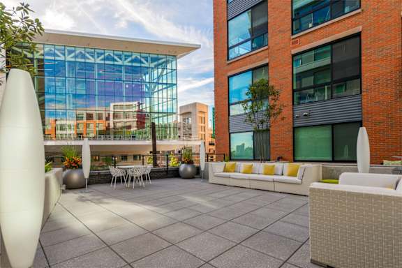 A modern outdoor seating area with white furniture and a large white sculpture.