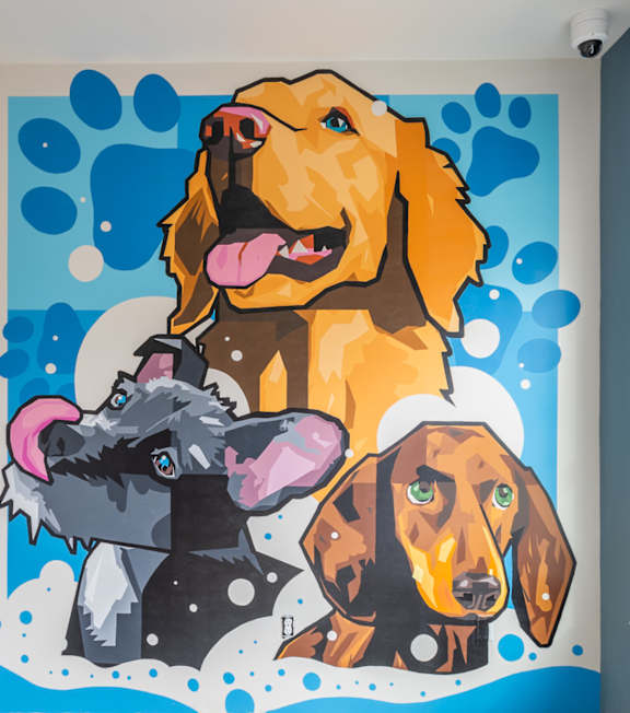 A mural of three dogs is painted on a wall. at Viridian Apartments LLC Apartments, Bowling Green
