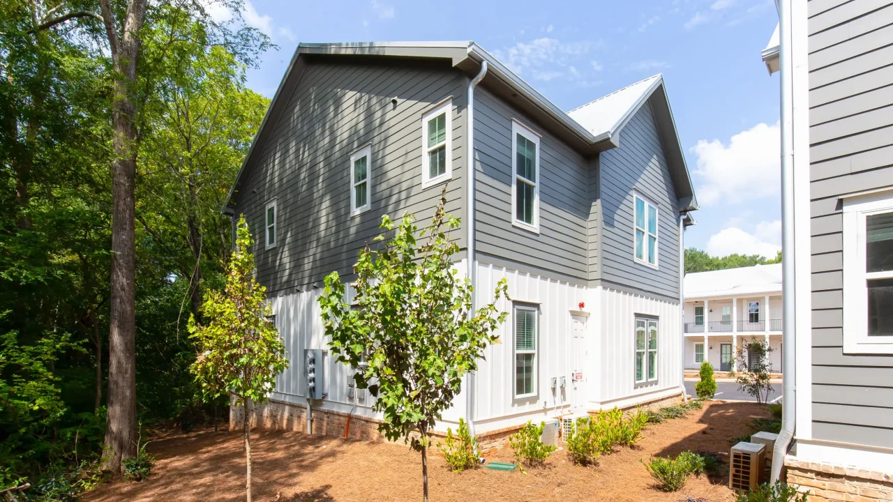 Exterior of The One Clemson student apartments with beautiful landscaping and walking paths at 135 Dean Way, offering a cozy off-campus home.