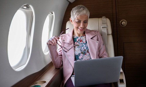 a woman working on a laptop in a plane