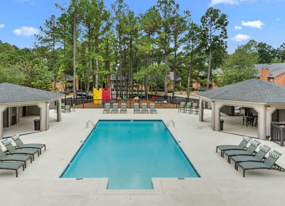 A large swimming pool surrounded by lounge chairs and trees. at Riverchase Landing, Hoover, 35244