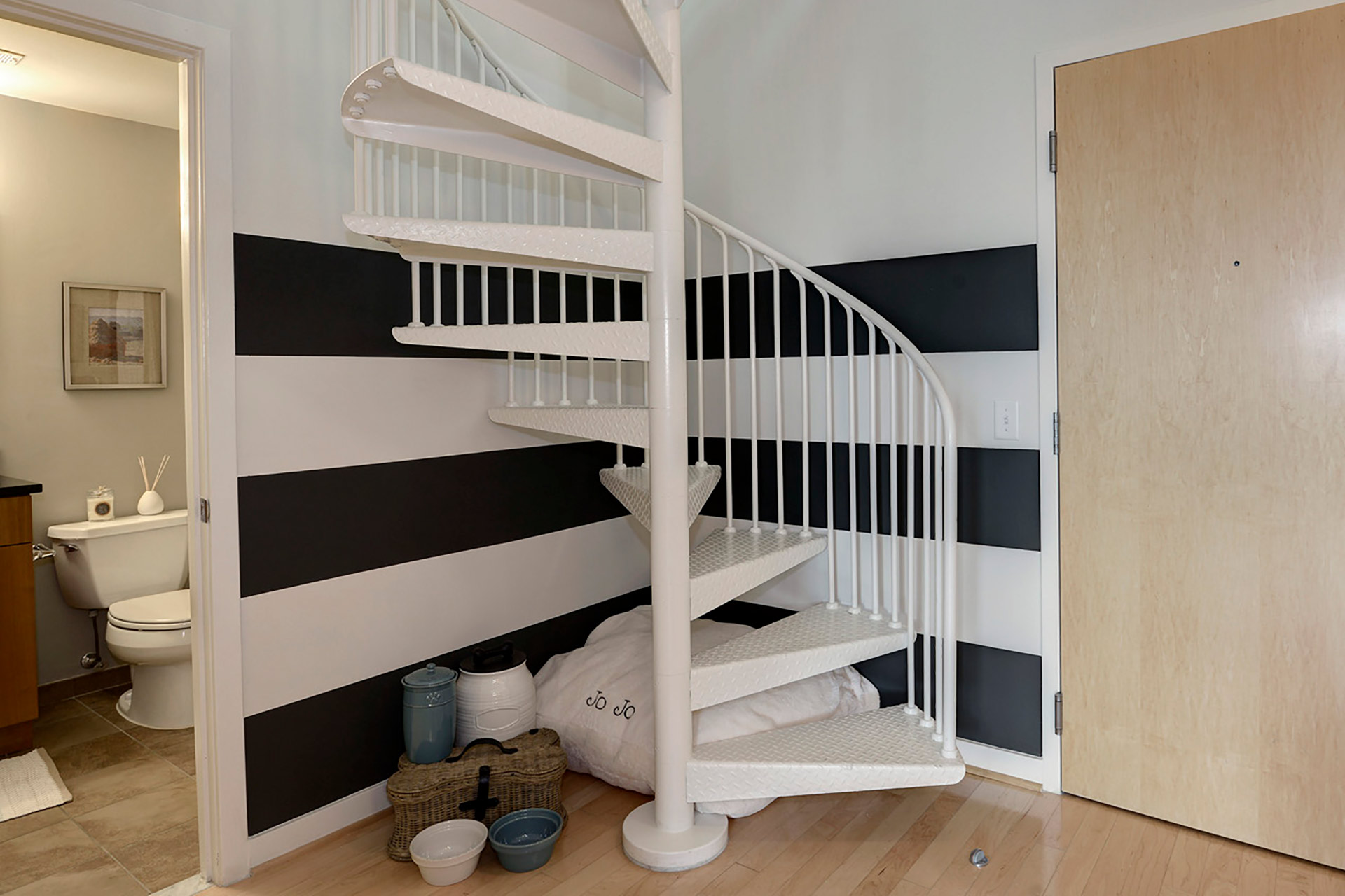 Closeup shot of loft staircase with view of bathroom and toilet through a door on the far left