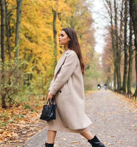 A women wearing a beige coat at Eastline Residences Apartments, Texas
